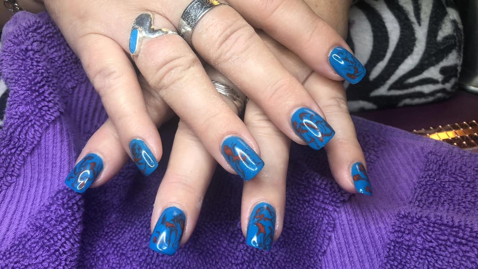 Blaue Nägel mit goldenem Muster